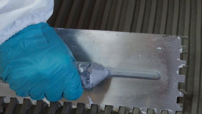 Spreading tile adhesive with notched trowel