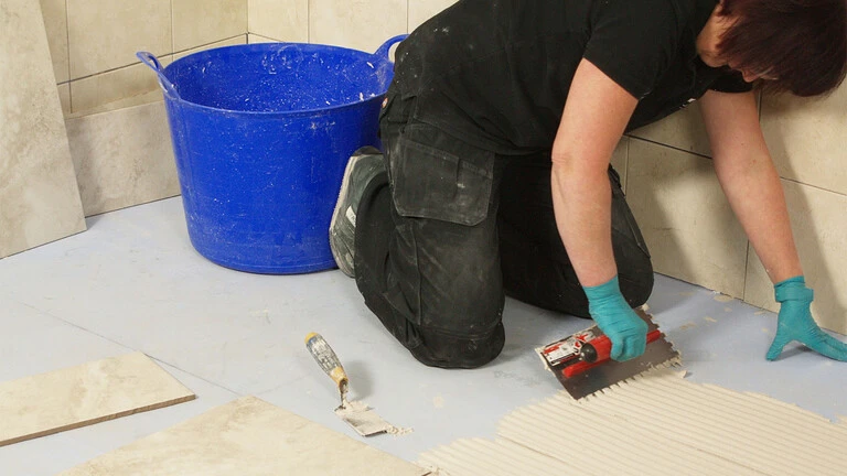 Applying tile adhesive onto floor